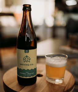 Vichy beer bottle mockup with one full glass beer on a table