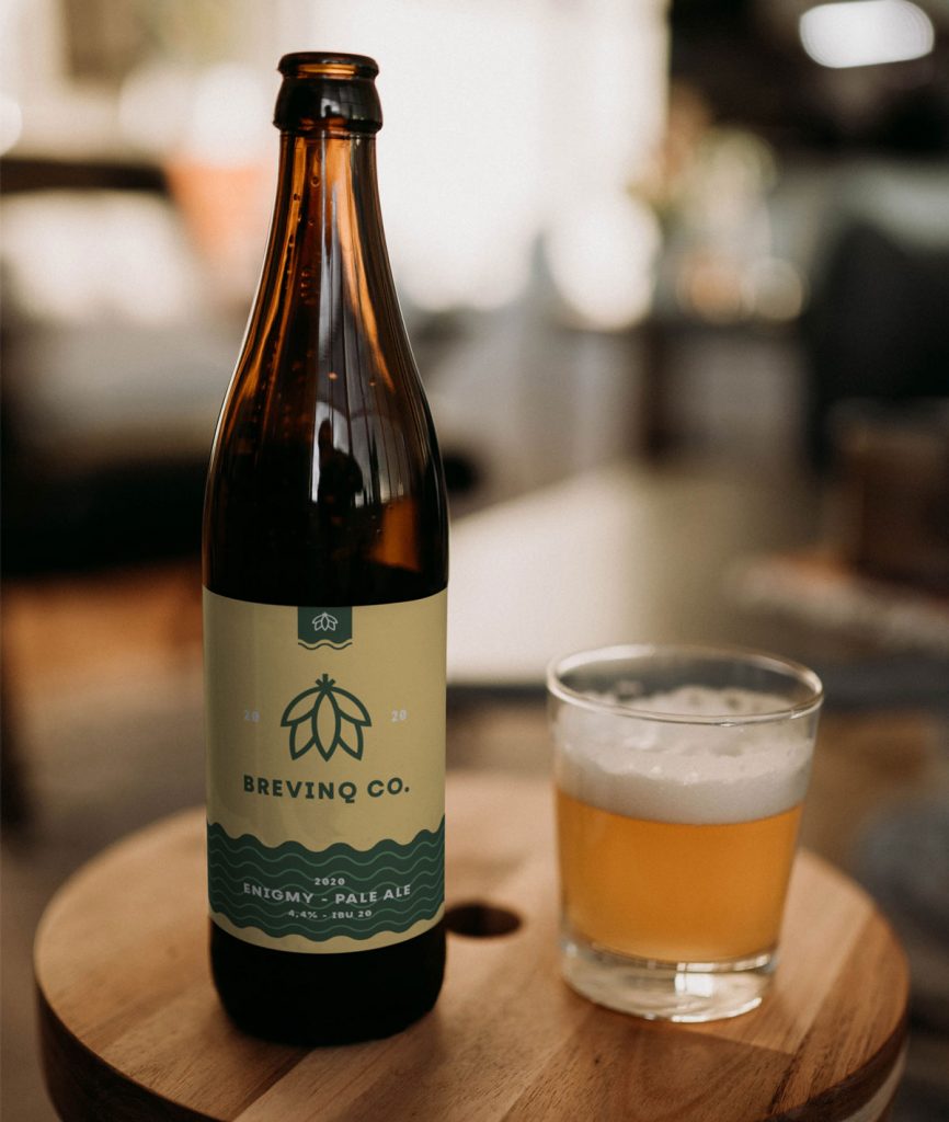 Vichy beer bottle mockup with one full glass beer on a table