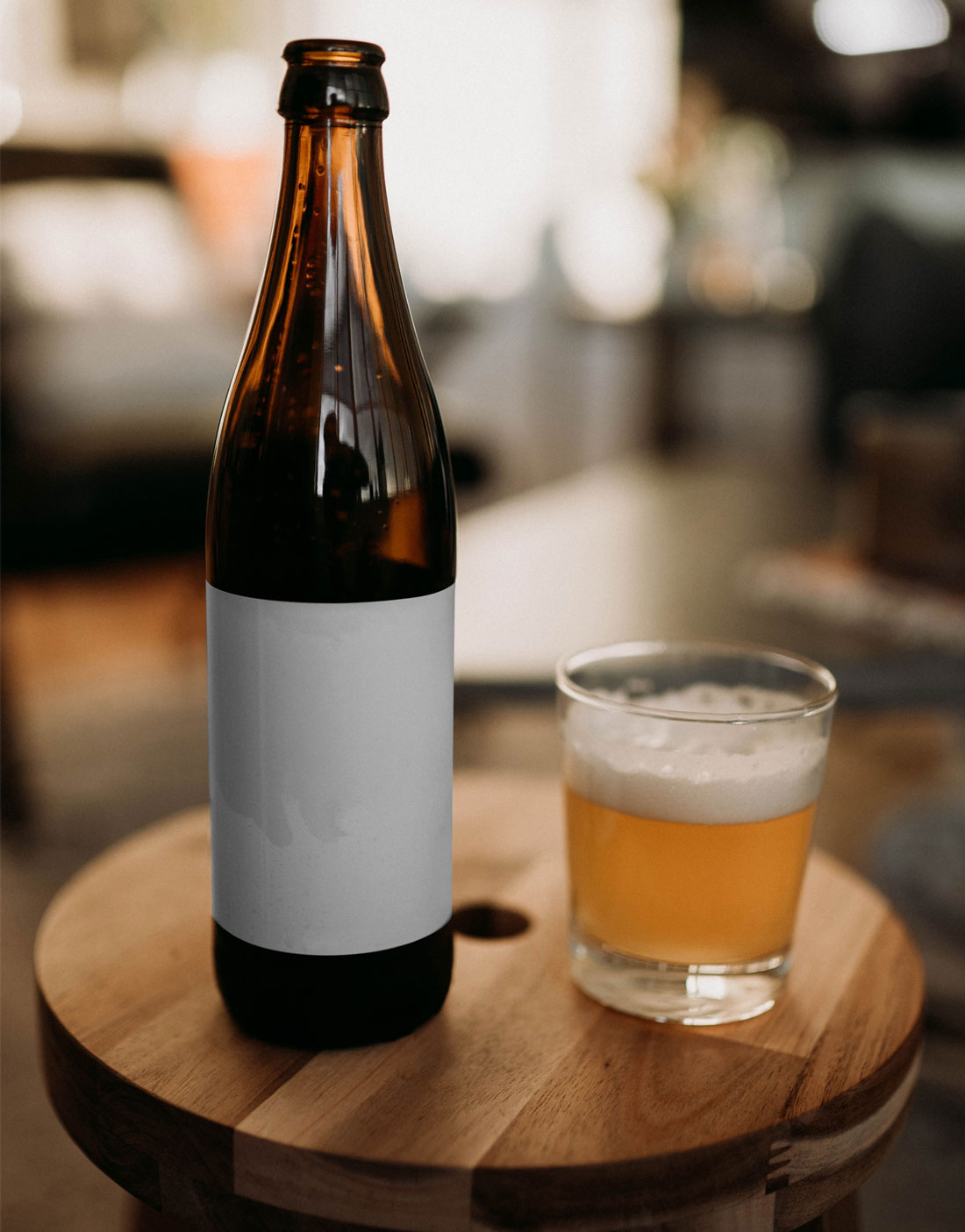 Vichy beer bottle mockup with one full glass beer on a table