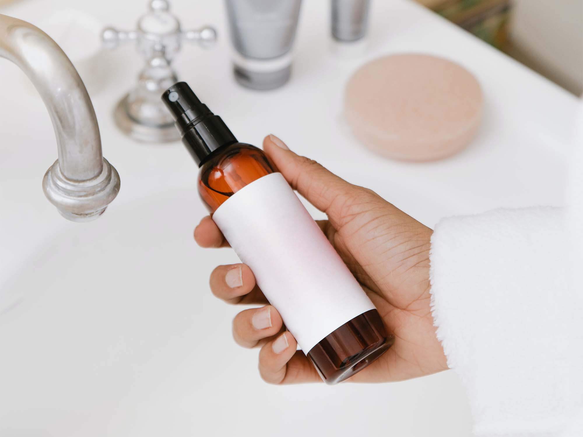 Free Spray Bottle in Hand Mockup PSD