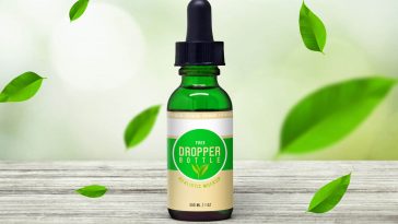 front view of glass dropper bottle on wooden surface mockup 1