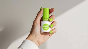 Free Hand Holding Nail Polish Bottle Mockup PSD