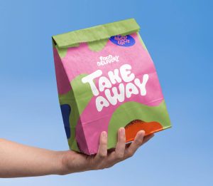 Delivery paper bag mockup PSD held in hand for food delivery and takeaway branding design